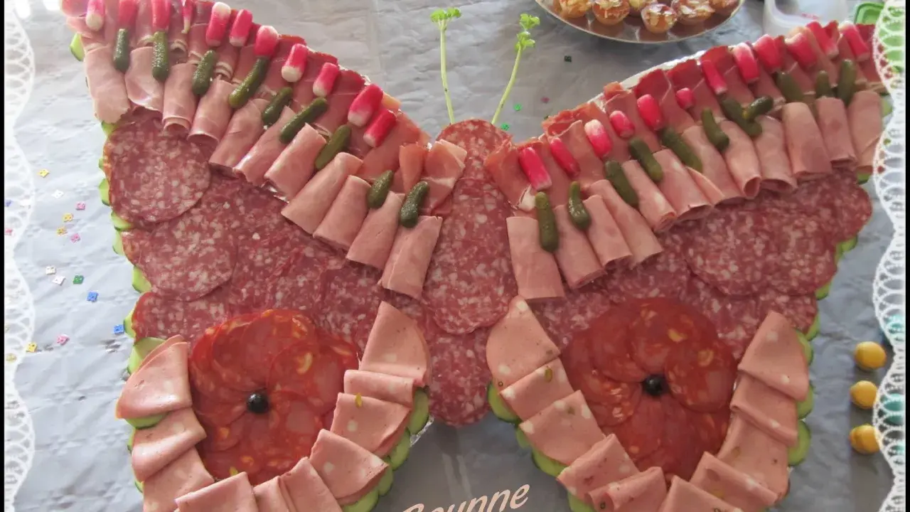 Un papillon charcuterie, composé de jambon, saucisson, cornichons et radis, prêt à émerveiller vos invités.