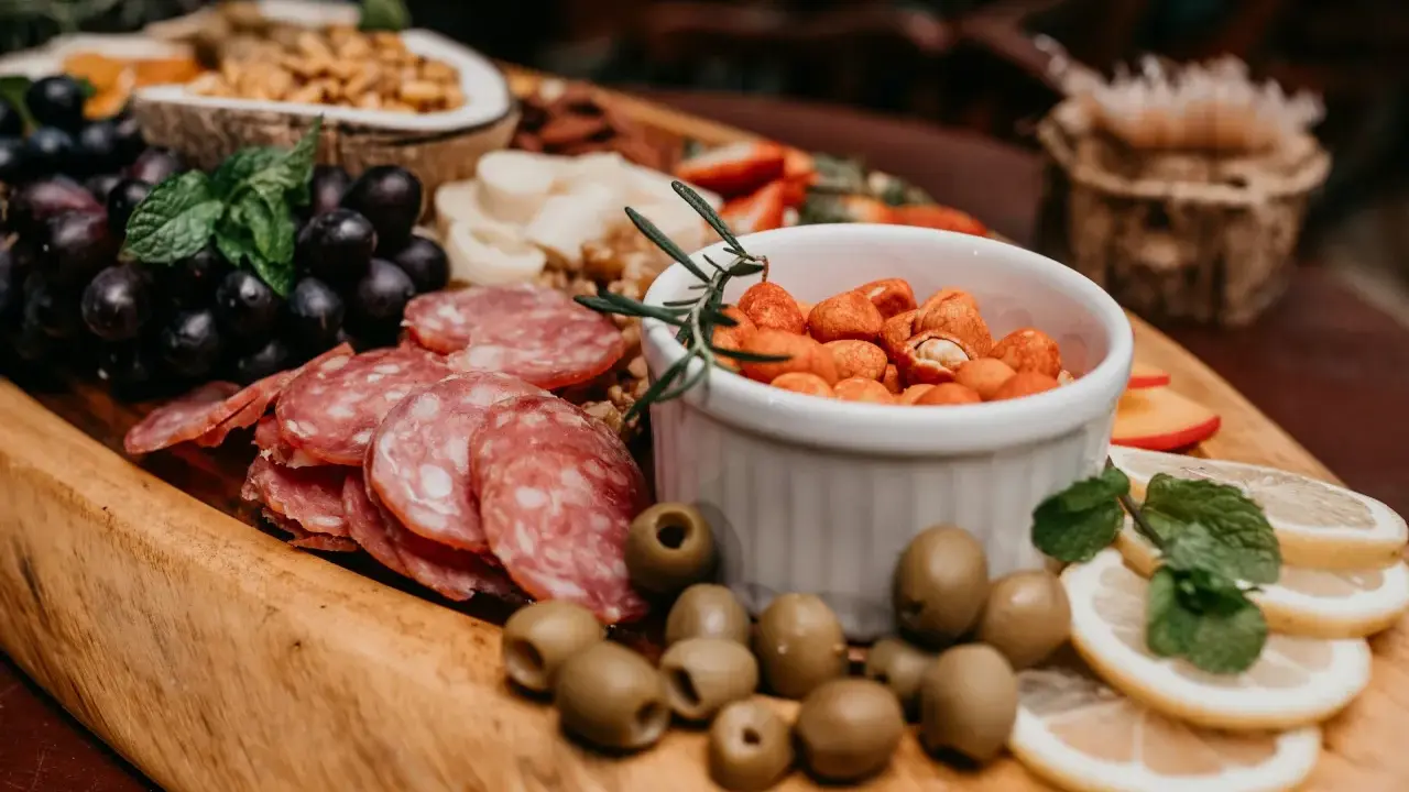 Plateau gourmand avec raisins, saucisson, olives, cacahuètes épicées et fruits. Un vrai menu campagnard !