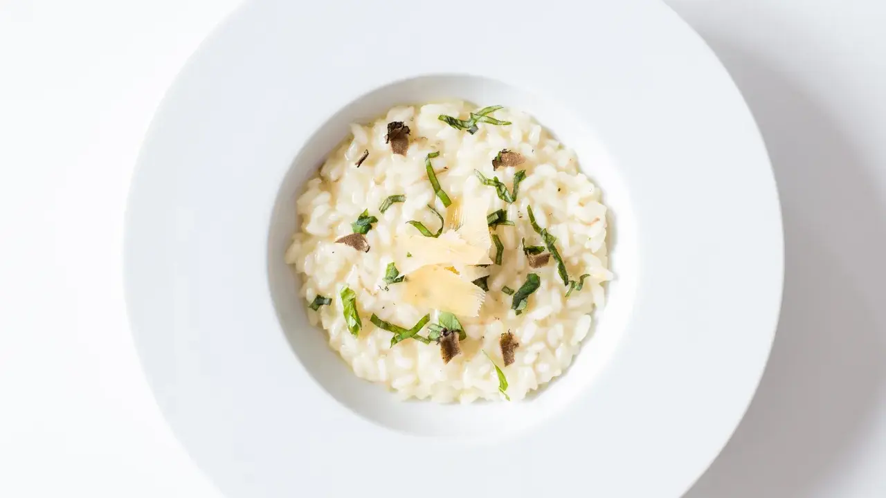 Un crémeux risotto à la truffe, parsemé de fines herbes et de copeaux de parmesan, un délice pour les sens.