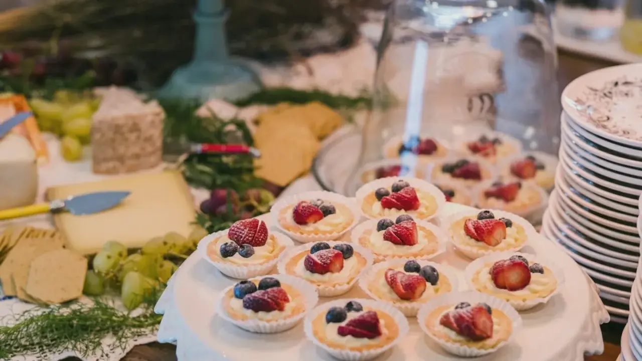 Un buffet de mariage avec des tartellettes aux fruits rouges, du fromage et des raisins. Une belle idée buffet mariage pour un événement gourmand.