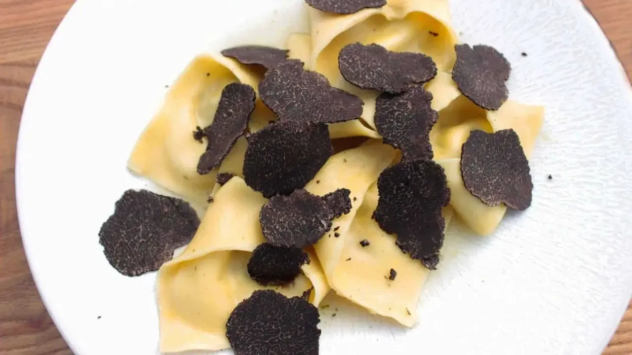 Délicieux raviolis frais garnis d'une généreuse quantité de lamelles de truffe noire. Un plat raffiné pour les amateurs de truffe.