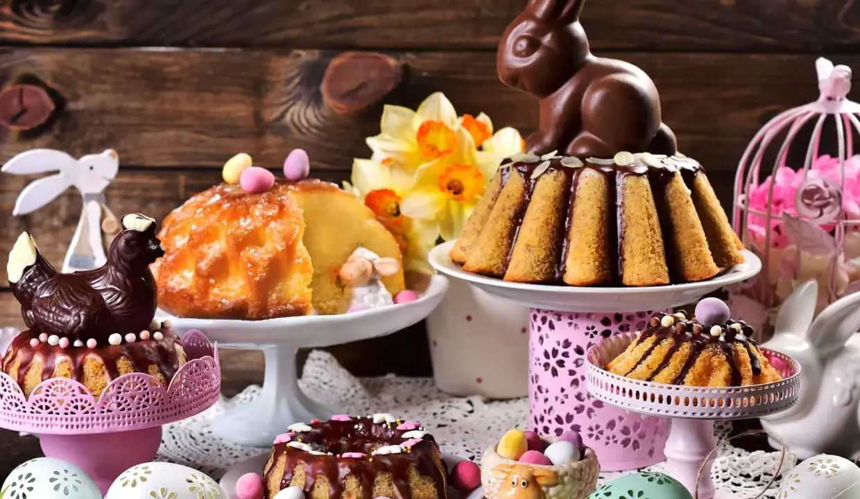 Un festin de Pâques : gâteaux, poule et lapin en chocolat, œufs décorés. Un vrai dessert de Pâques traditionnel pour célébrer.