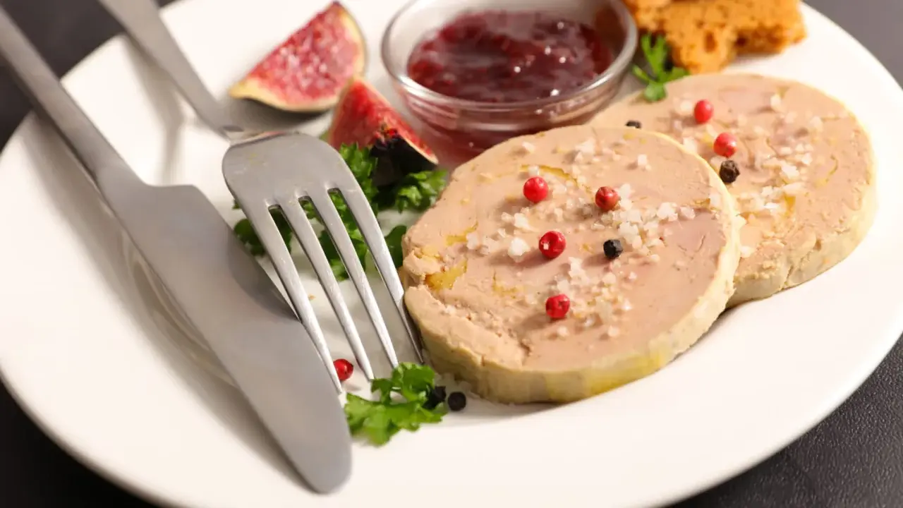 Assiette de foie gras, figues, confiture de fruits rouges et toasts. Une présentation raffinée pour un délice.