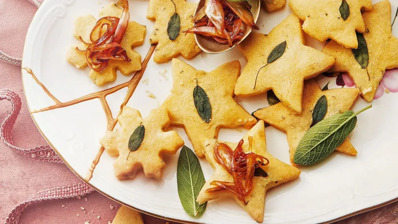 Biscuits en forme d'étoiles et de flocons, décorés de feuilles de sauge et d'oignons caramélisés. Un délice pour un repas de Noël pour enfant.