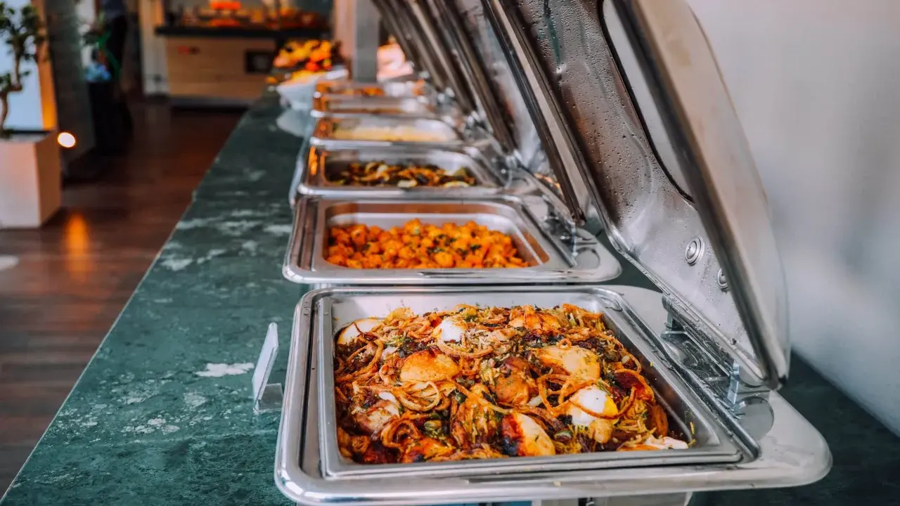 Buffet de plats chauds, idéal pour un pique-nique gourmand. Des mets variés dans des chafing dishes brillants.