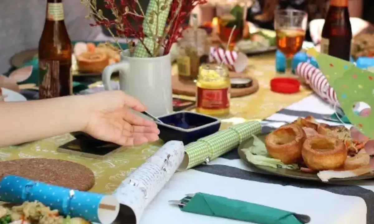 Table dressée pour un repas convivial, parfait pour une idée repas kermesse école. Yorkshire puddings, salade et bouteilles de bière.