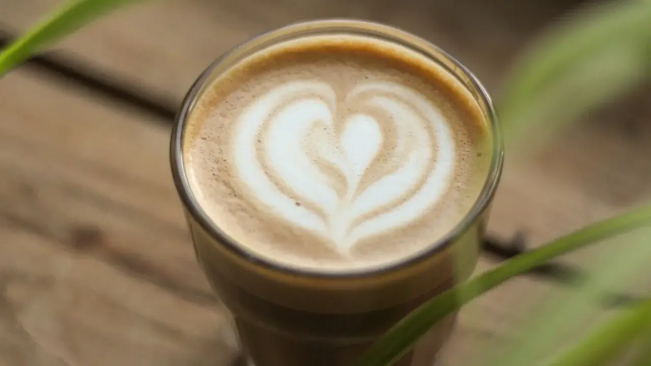Un latte parfait avec un cœur dessiné dans la mousse. Une invitation à découvrir une recette latte simple et délicieuse.