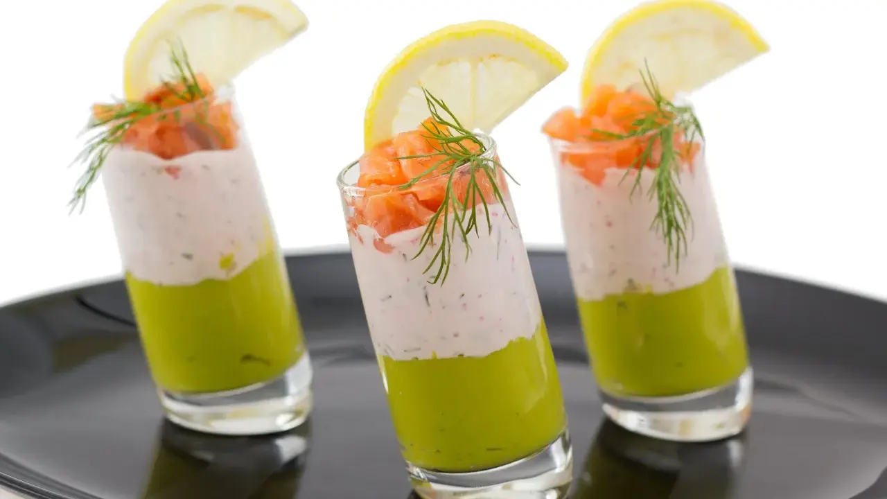Trois verrines végétariennes colorées, garnies de saumon, d'une crème légère et d'une tranche de citron.