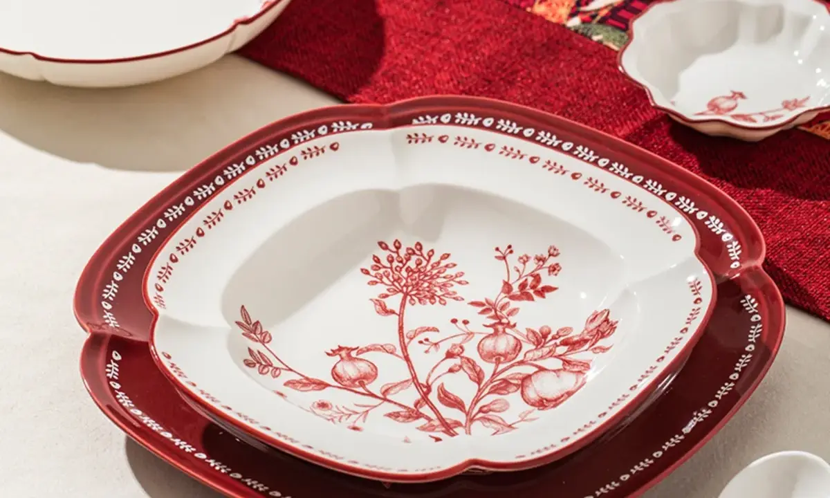 Assiette décorative rouge et blanche avec motif floral, parfaite pour servir, mais attention, cette assiette qui ne chauffe pas au micro onde est fragile.