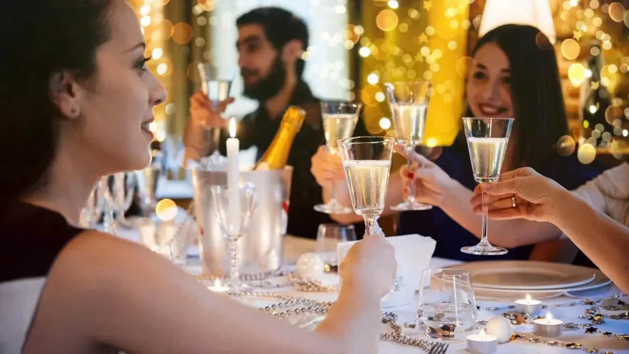 Des amis trinquant avec du champagne lors d'une fête. Une belle idée jeu du goût adulte pour animer la soirée.