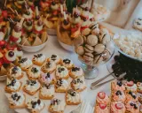 Délicieux assortiment de douceurs pour un brunch mariage : brochettes de fruits, mini gaufres à la crème, macarons et autres gourmandises.