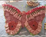 Un papillon charcuterie, composé de jambon, saucisson, cornichons et radis, prêt à émerveiller vos invités.