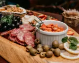 Plateau gourmand avec raisins, saucisson, olives, cacahuètes épicées et fruits. Un vrai menu campagnard !