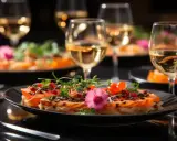 Un délicieux repas EVJF avec des assiettes raffinées, des garnitures colorées et des verres de vin blanc pétillant.