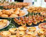 Buffet d'entrée pour un repas d'anniversaire adulte : mini-quiches, feuilletés, tartes salées, pizzas et amuse-bouches.
