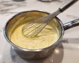 Préparation d'une crème onctueuse pour un flan Cyril Lignac, avec un fouet en action.