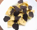 Délicieux raviolis frais garnis d'une généreuse quantité de lamelles de truffe noire. Un plat raffiné pour les amateurs de truffe.