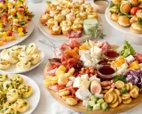 Plateau de petits fours salés froids : brochettes de légumes colorés, roulés, mini-sandwichs et assortiment de fromages et charcuteries.