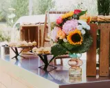 Un buffet de mini-burgers et un bouquet coloré, une belle idée apéro mariage en plein air.