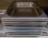 Pile de bacs gastro en inox, prêts à accueillir vos préparations culinaires.