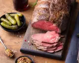 Un rôti de bœuf froid, tranché, prêt à servir pour 20 personnes. Accompagné de cornichons croquants et de moutarde à l'ancienne.