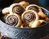 Un bol rempli de feuilletés tapenade, des roulés dorés à la pâte feuilletée croustillante et à la garniture sombre et savoureuse.
