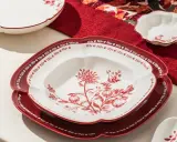 Assiette décorative rouge et blanche avec motif floral, parfaite pour servir, mais attention, cette assiette qui ne chauffe pas au micro onde est fragile.