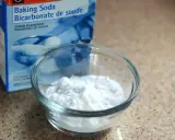Un bol de bicarbonate de soude à côté de sa boîte. Un ingrédient polyvalent, utile pour le nettoyage et la cuisine, et même pour des expériences scientifiques impliquant de l'aluminium.
