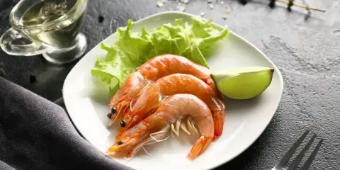 Assiette de crevettes avec laitue et citron vert. Une question se pose : combien de crevettes par personne pour ce délice ?