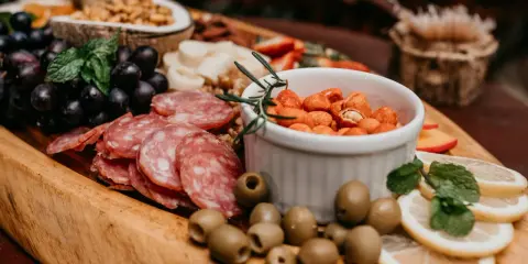 Plateau gourmand avec raisins, saucisson, olives, cacahuètes épicées et fruits. Un vrai menu campagnard !