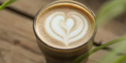 Un latte parfait avec un cœur dessiné dans la mousse. Une invitation à découvrir une recette latte simple et délicieuse.