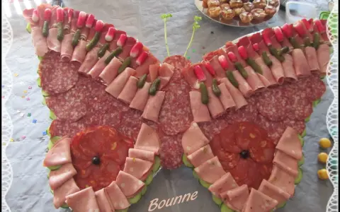 Un papillon charcuterie, composé de jambon, saucisson, cornichons et radis, prêt à émerveiller vos invités.