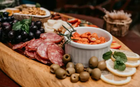 Plateau gourmand avec raisins, saucisson, olives, cacahuètes épicées et fruits. Un vrai menu campagnard !