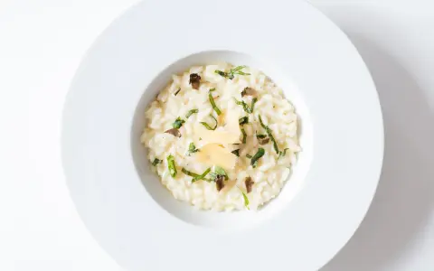Un crémeux risotto à la truffe, parsemé de fines herbes et de copeaux de parmesan, un délice pour les sens.