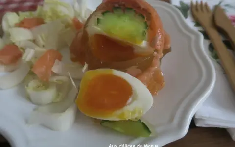 Un œuf en gelée au saumon, garni de concombre et servi avec des dés de saumon fumé et des endives. Un délice !