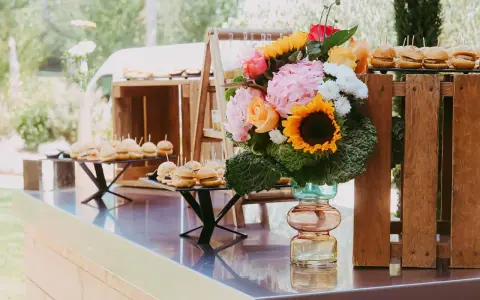 Un buffet de mini-burgers et un bouquet coloré, une belle idée apéro mariage en plein air.
