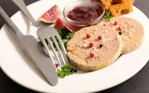 Assiette de foie gras, figues, confiture de fruits rouges et toasts. Une présentation raffinée pour un délice.