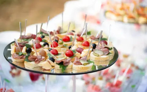 Plateau de petits fours variés, parfaits pour une idée repas baptême. Mini-brochettes avec tomates cerises, olives, charcuterie et fromage sur pain.