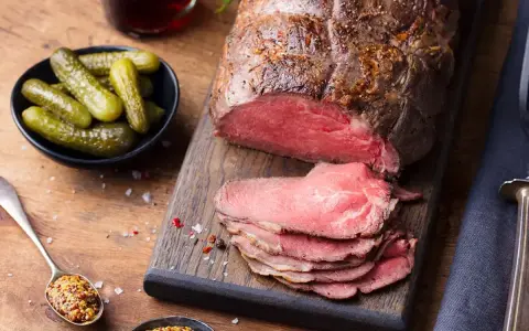 Un rôti de bœuf froid, tranché, prêt à servir pour 20 personnes. Accompagné de cornichons croquants et de moutarde à l'ancienne.