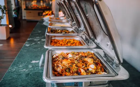 Buffet de plats chauds, idéal pour un pique-nique gourmand. Des mets variés dans des chafing dishes brillants.