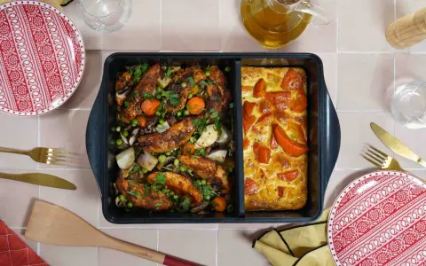 Comment savoir si un plat va au four ? Ce plat divisé présente du poulet rôti aux légumes d'un côté et un gratin de tomates de l'autre.