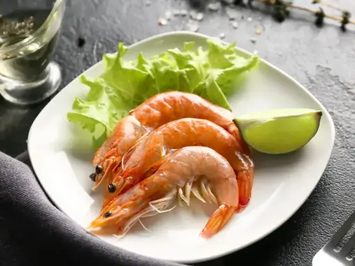 Assiette de crevettes avec laitue et citron vert. Une question se pose : combien de crevettes par personne pour ce délice ?