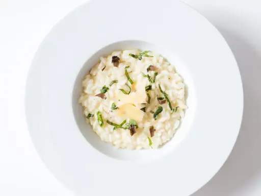Un crémeux risotto à la truffe, parsemé de fines herbes et de copeaux de parmesan, un délice pour les sens.