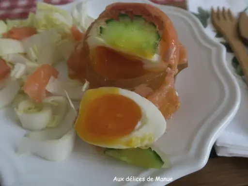 Un œuf en gelée au saumon, garni de concombre et servi avec des dés de saumon fumé et des endives. Un délice !