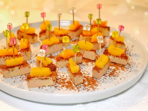 Des bouchées de foie gras surmontées de fruits et décorées de broyés, une façon originale de servir ce délice.