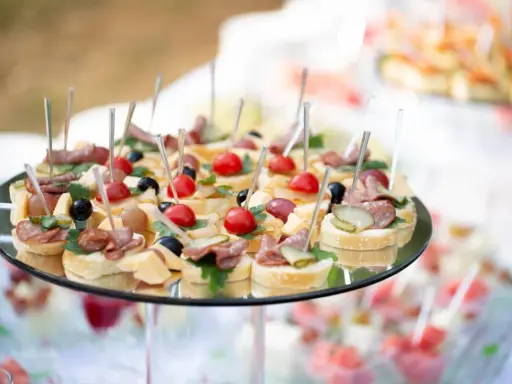 Plateau de petits fours variés, parfaits pour une idée repas baptême. Mini-brochettes avec tomates cerises, olives, charcuterie et fromage sur pain.