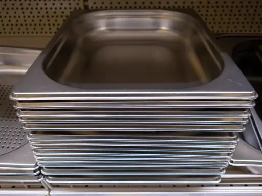 Pile de bacs gastro en inox, prêts à accueillir vos préparations culinaires.