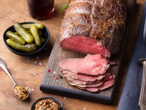 Un rôti de bœuf froid, tranché, prêt à servir pour 20 personnes. Accompagné de cornichons croquants et de moutarde à l'ancienne.