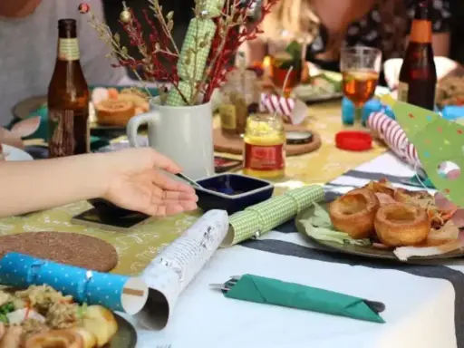 Table dressée pour un repas convivial, parfait pour une idée repas kermesse école. Yorkshire puddings, salade et bouteilles de bière.