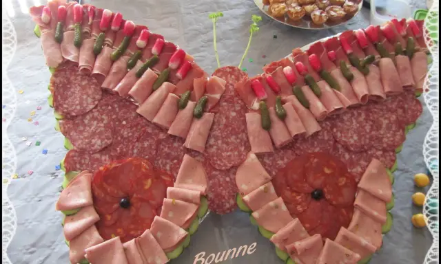 Un papillon charcuterie, composé de jambon, saucisson, cornichons et radis, prêt à émerveiller vos invités.